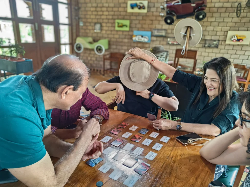 Guests playing a board game together indoors at Arbor Road Estate near Hyderabad.