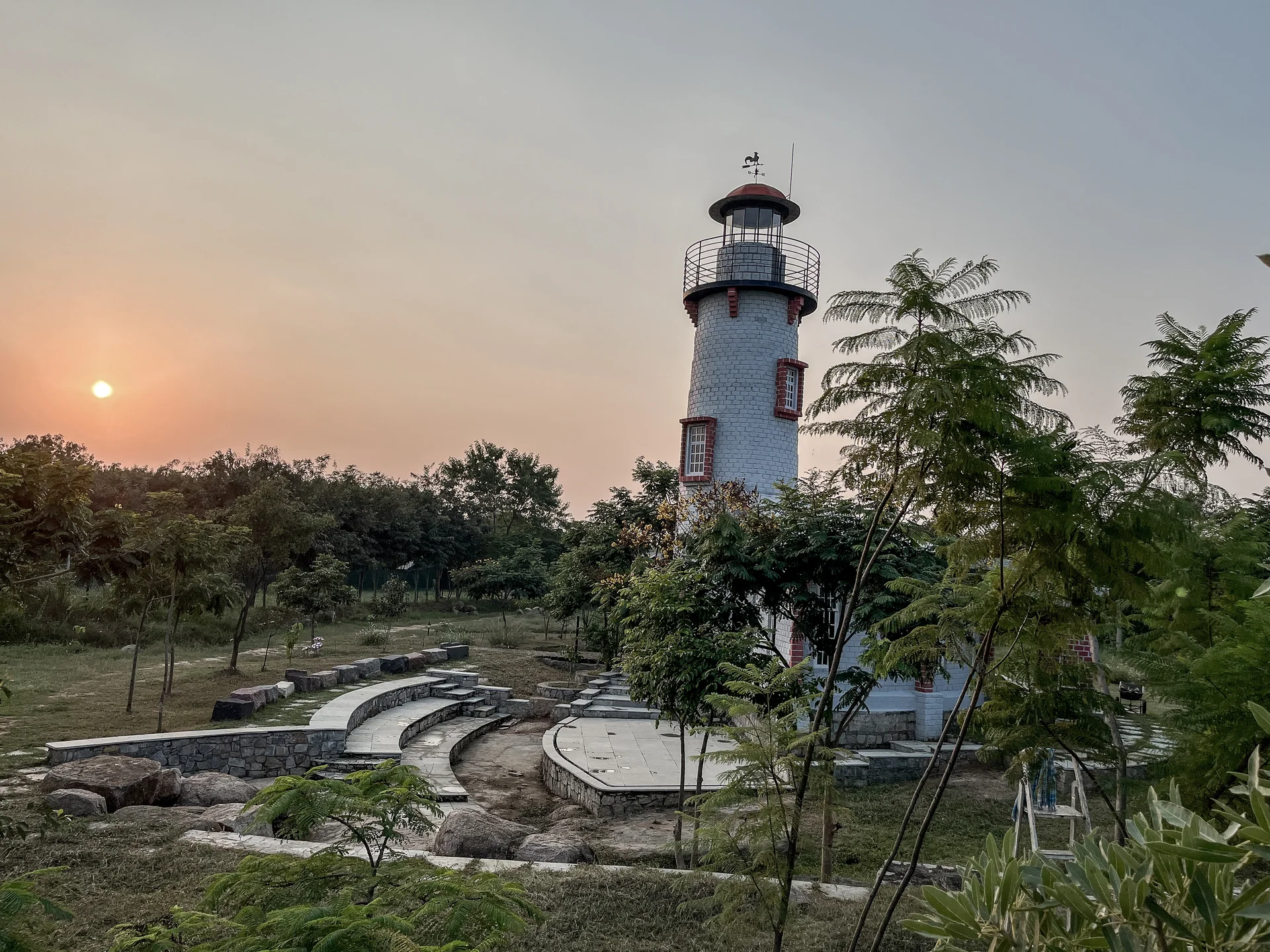 Lighthouse above Deccan rocks and gardens at sunset at Arbor Road Estate near Hyderabad.